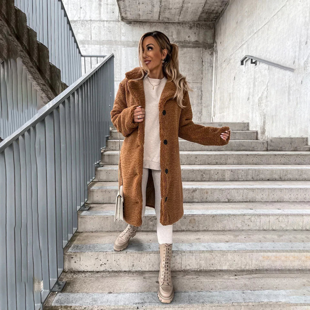 "Lange teddy jas dames, elegant beige, luxe winter mode, zachte stof, geschikt voor zowel formele als casual gelegenheden."