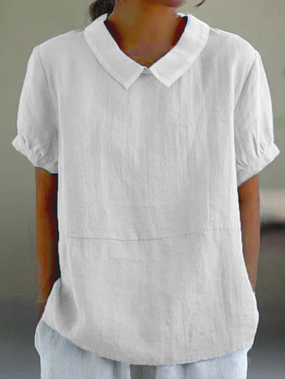 "Lichtblauwe Avaya blouse van katoen met korte mouwen, ronde kraag en subtiele details, ideaal voor zomerse dagen."