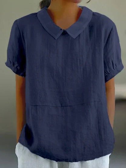 "Lichtblauwe Avaya blouse van katoen met korte mouwen, ronde kraag en subtiele details, ideaal voor zomerse dagen."