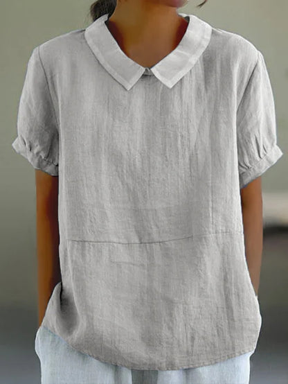 "Lichtblauwe Avaya blouse van katoen met korte mouwen, ronde kraag en subtiele details, ideaal voor zomerse dagen."
