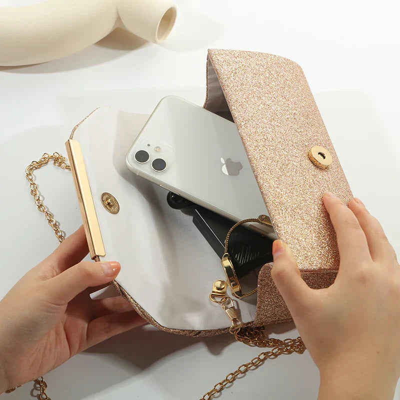 "Luxe gouden clutch met glitters, elegante sluiting en verwijderbare band, perfect voor avondgelegenheden."