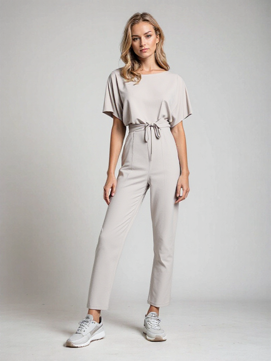 "Sophie dames jumpsuit, elegant met korte mouwen en flatterende taille in beige, ideaal voor elke gelegenheid."