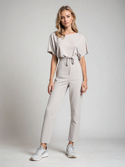 "Sophie dames jumpsuit, elegant met korte mouwen en flatterende taille in beige, ideaal voor elke gelegenheid."