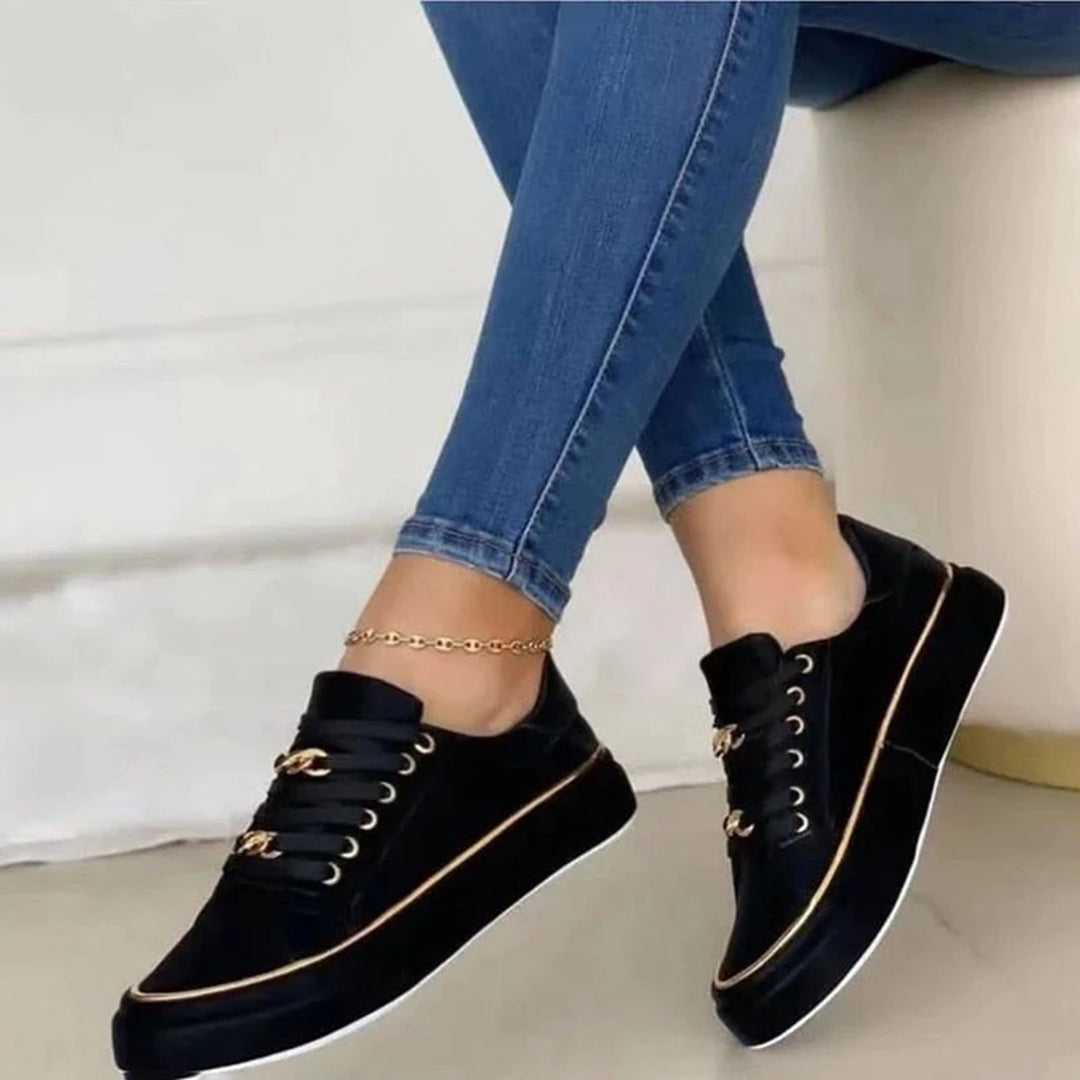 "Stijlvolle dames sneakers met gouden accenten, wit en zwart ontwerp. Chique en comfortabel voor elke gelegenheid."