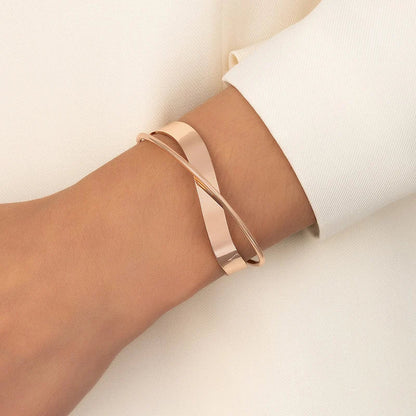 "Stijlvolle goudkleurige armband met kruissymbool, verstelbaar ontwerp voor dames, ideaal als mix & match sieraad."