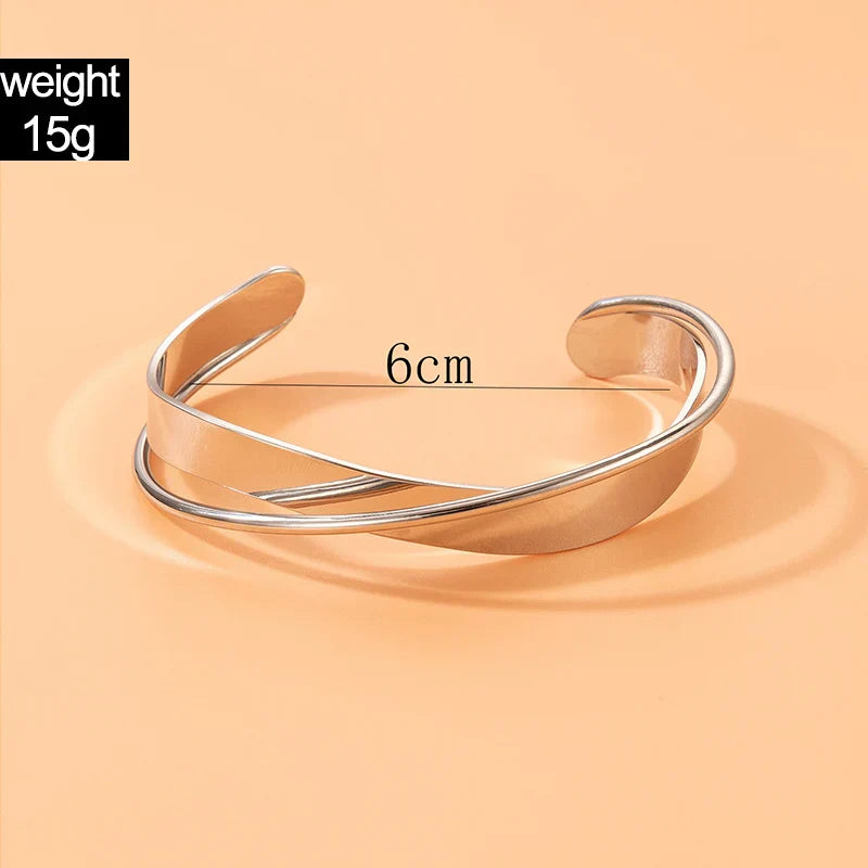 "Stijlvolle goudkleurige armband met kruissymbool, verstelbaar ontwerp voor dames, ideaal als mix & match sieraad."