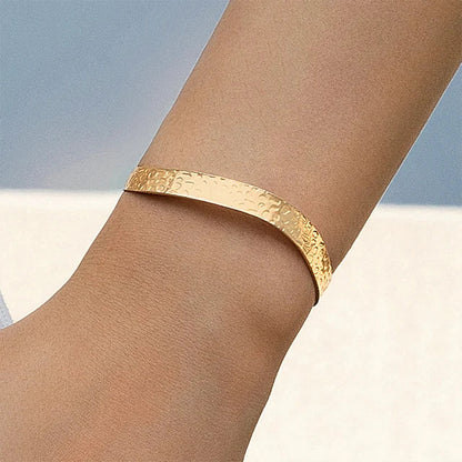 "Stijlvolle goudkleurige armband met kruissymbool, verstelbaar ontwerp voor dames, ideaal als mix & match sieraad."