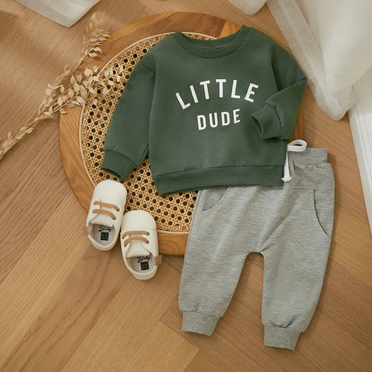 "Stoere herfstoutfit voor jongens met een kleurrijke letterprint trui en comfortabele broek, perfect voor actieve peuters."