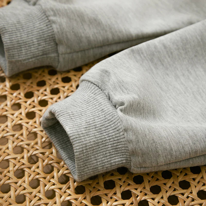 "Stoere herfstoutfit voor jongens met een kleurrijke letterprint trui en comfortabele broek, perfect voor actieve peuters."