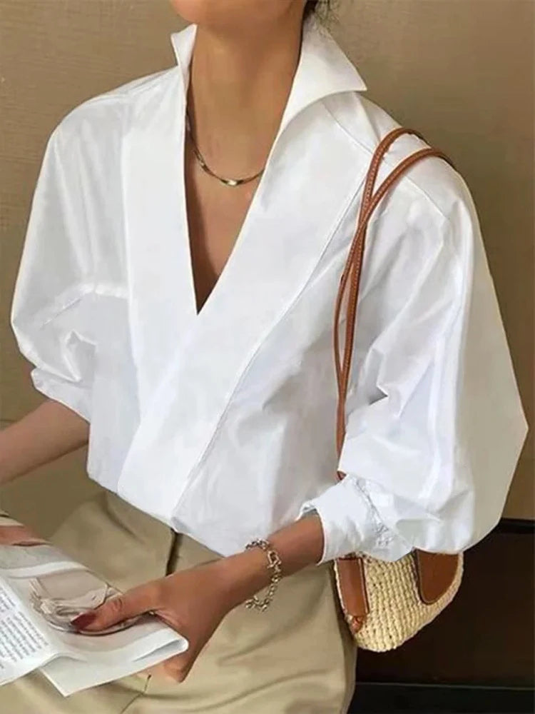"Witte damesblouse met pofmouwen en V-hals; ademende stof; elegante en comfortabele look, perfect voor lente en zomer."