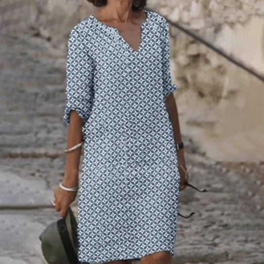 "Zomerjurk NORA: elegant ontwerp, ademende stof, verkrijgbaar in blauw, bruin, grijs, groen. Perfect voor zonnige dagen."