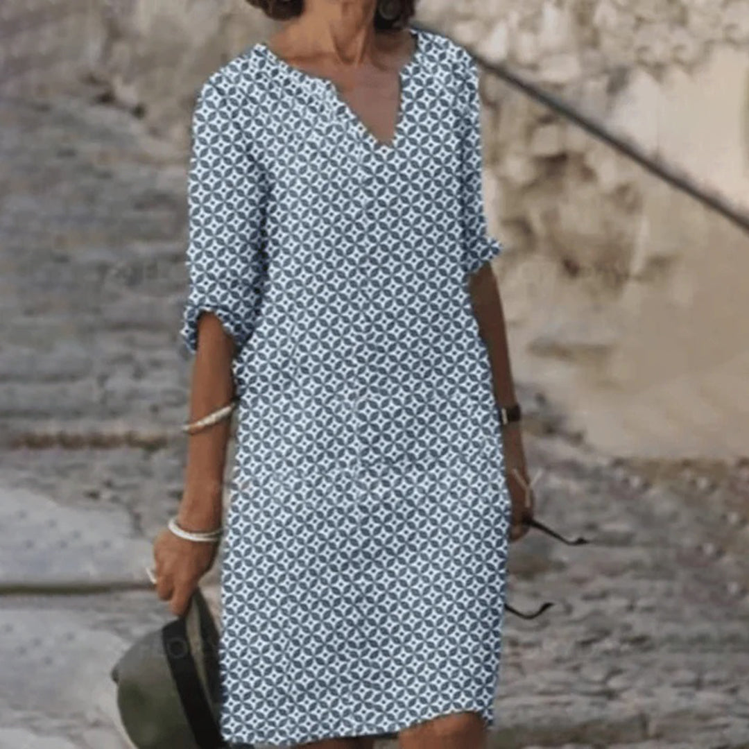 "Zomerjurk NORA: elegant ontwerp, ademende stof, verkrijgbaar in blauw, bruin, grijs, groen. Perfect voor zonnige dagen."