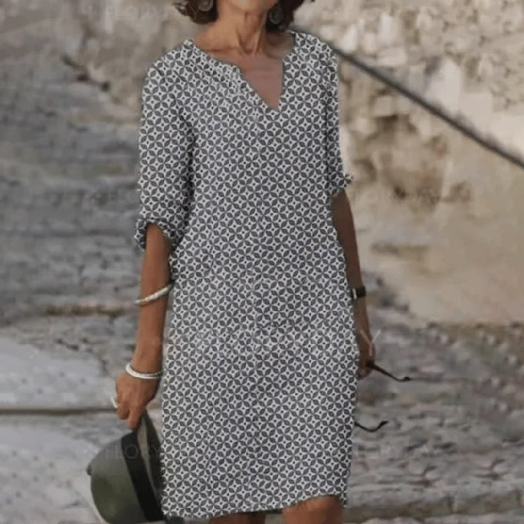 "Zomerjurk NORA: elegant ontwerp, ademende stof, verkrijgbaar in blauw, bruin, grijs, groen. Perfect voor zonnige dagen."