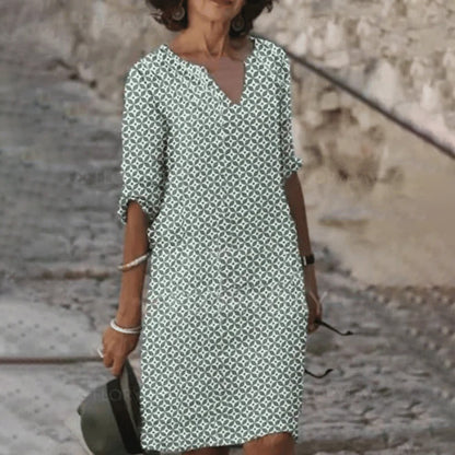"Zomerjurk NORA: elegant ontwerp, ademende stof, verkrijgbaar in blauw, bruin, grijs, groen. Perfect voor zonnige dagen."