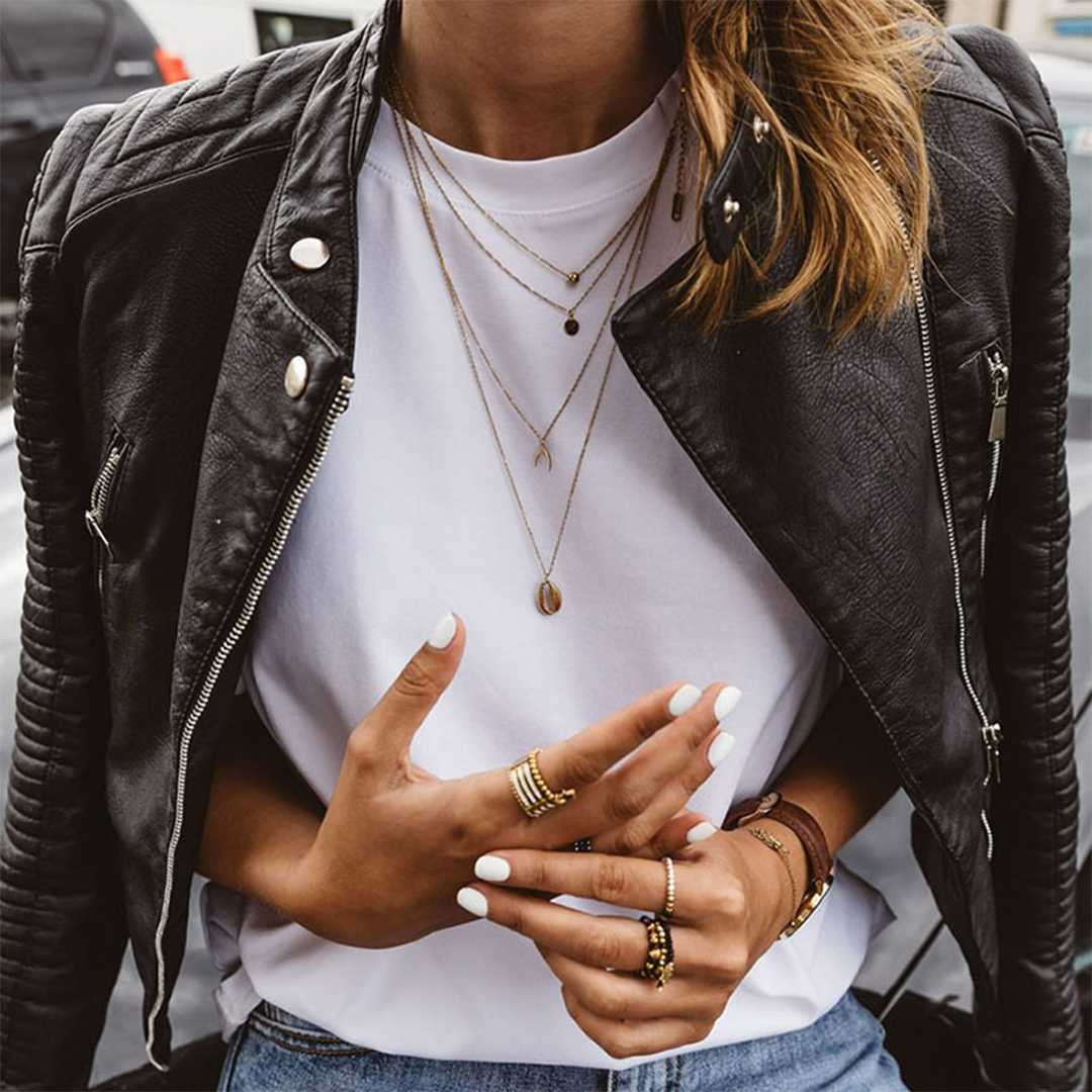 Zwarte leren damesjas in bikerstijl, met metalen ritsen en studs; geschikt voor zomer en herfst. Tijdloze elegantie.