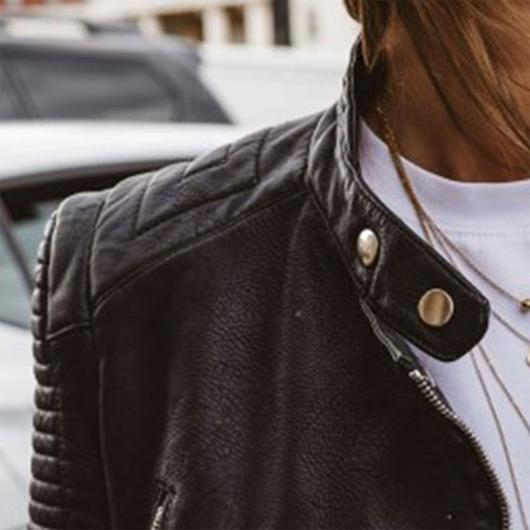 Zwarte leren damesjas in bikerstijl, met metalen ritsen en studs; geschikt voor zomer en herfst. Tijdloze elegantie.